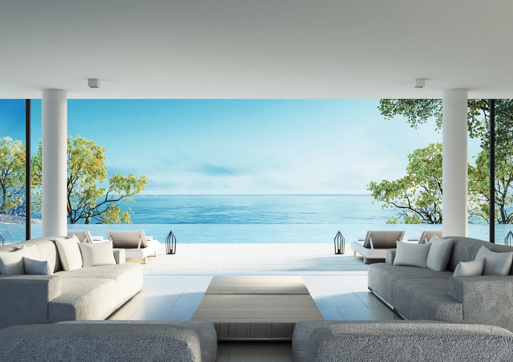 White lounge with opposing sofas and a wide opening overlooking a terrace and the sea