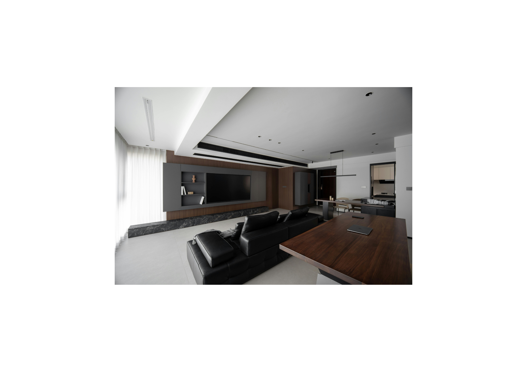 Small inset view of a modern living room with black leather sofas, a timber table and a wall-mounted television
