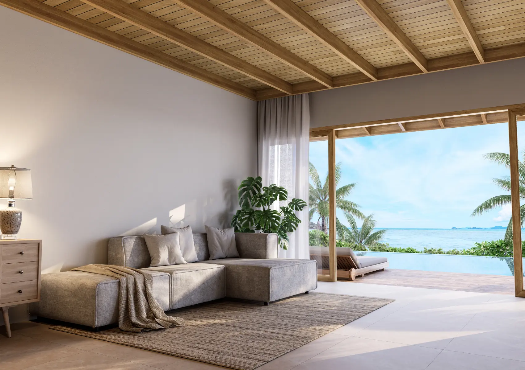 Villa living room with an exposed timber ceiling, neutral sofa and open doors towards palms and the sea